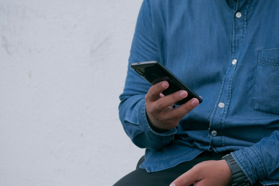 a person holding an android mobile device with a blue shirt